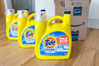 three yellow detergent bottles on a floor in front of an Amazon box