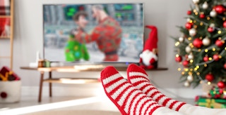 christmas cartoons movies person in living room watching holiday cartoons feature