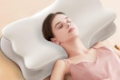 a woman using a cervical neck pillow