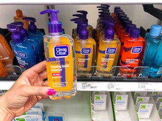 hand holding clean and clear face wash in front store shelf