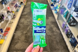 person holding a gillette disposable razor in an aisle
