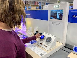 A woman testing out a Nest thermostat on the Nest display inside Best Buy.