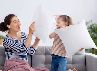 a mom and daughter holding small pillows