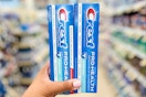 Hand holding two boxes of Crest Pro-Health toothpaste