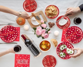 a table with food and Valentine's Day plates and utensils