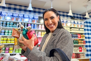 a woman shopping at Bath & Body Works with her hands full of products