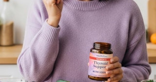 a person holding a bottle of supplements