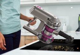 a person cleaning a counter with a vacuum 