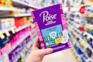 person holding a package of poise pads in an aisle