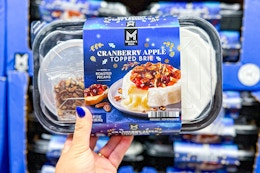 hand holding a pack of members mark brie