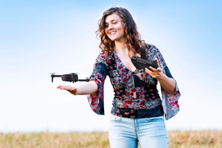 Lifestyle image of the AUOSHI Mini Drone being used by a woman outdoors