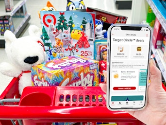 hand holding cellphone with target circle app open infront of a cart filled with toys