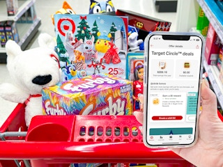 hand holding cellphone with target circle app open infront of a cart filled with toys