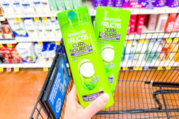 hand holding two bottles of garnier fructis hair care