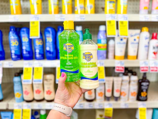 person holding banana boat aloe in front of shelves with sunscreen