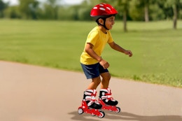 Lifestyle image of a small child wearing/using the Halo Inline Skates Combo Set outdoors