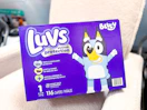 A box of Luvs Bluey Diapers on nursery chair in baby section of Walmart