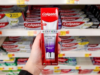 hand holding colgate toothpaste boz at Walmart