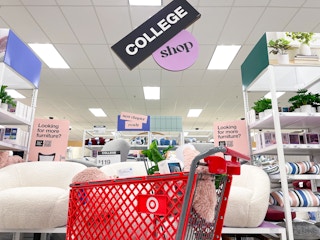 A Target shopping cart filled with items, parked in the College Shop section in Target.
