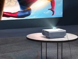 a projector on a table showing a Spiderman movie