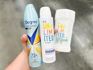 hand holding two Degree dry sprays and one deodorant