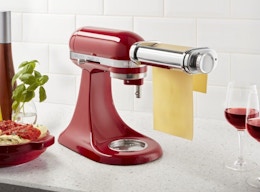 a KitchenAid mixer rolling pasta dough in a kitchen