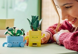 child playing with the blue and yellow happy plant lego set