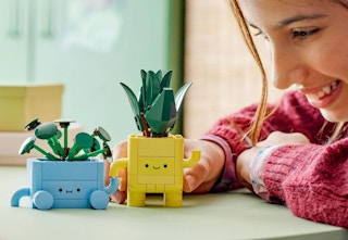 child playing with the blue and yellow happy plant lego set