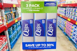 hand holding a pack of q tips