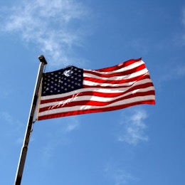 http://www.photos-public-domain.com/2011/03/23/american-flag-against-blue-sky/