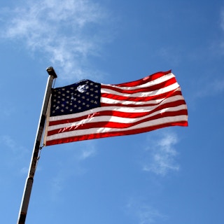 http://www.photos-public-domain.com/2011/03/23/american-flag-against-blue-sky/