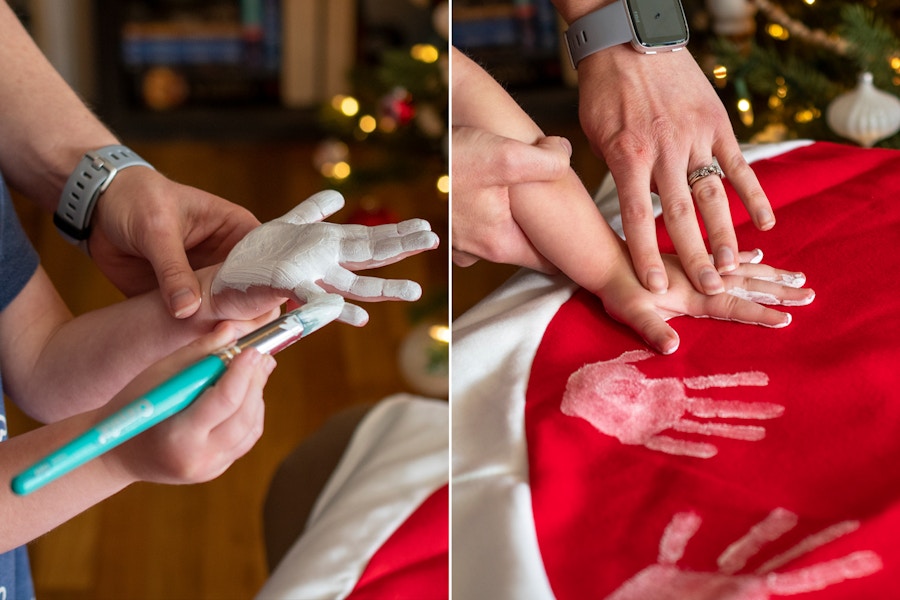 Two photos. An adult using white paint to paint the palm of a child's hand then pressing a child hand covered in paint to a tree skirt