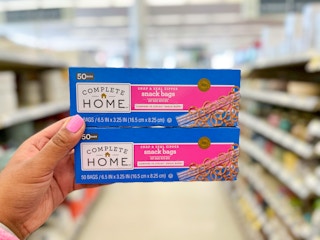 hand holding two boxes of complete home bags