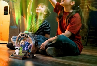 two kids looking at the lights on a galaxy projector