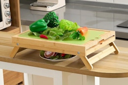 Remerry Large Raised Bamboo Cutting Board with Foldable Legs sitting on a kitchen counter.
