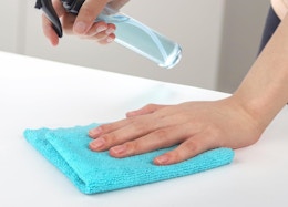 a person cleaning with a blue dishcloth