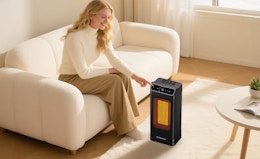 a person sitting in front of a space heater