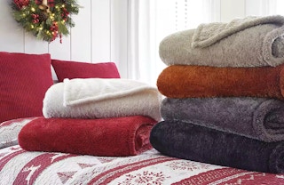 a stack of teddy sherpa blankets on a bed
