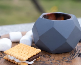 mini fire pit on a table with s'mores