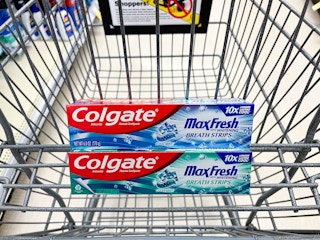 Two boxes of Colgate MaxFresh toothpaste stacked in a Walgreens shopping cart basket.