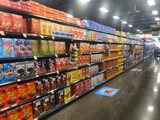 Grocery store aisle with shelves filled with cereal.