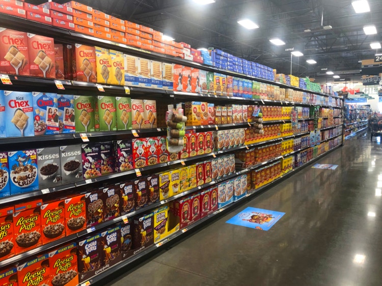 Grocery store aisle with shelves filled with cereal.