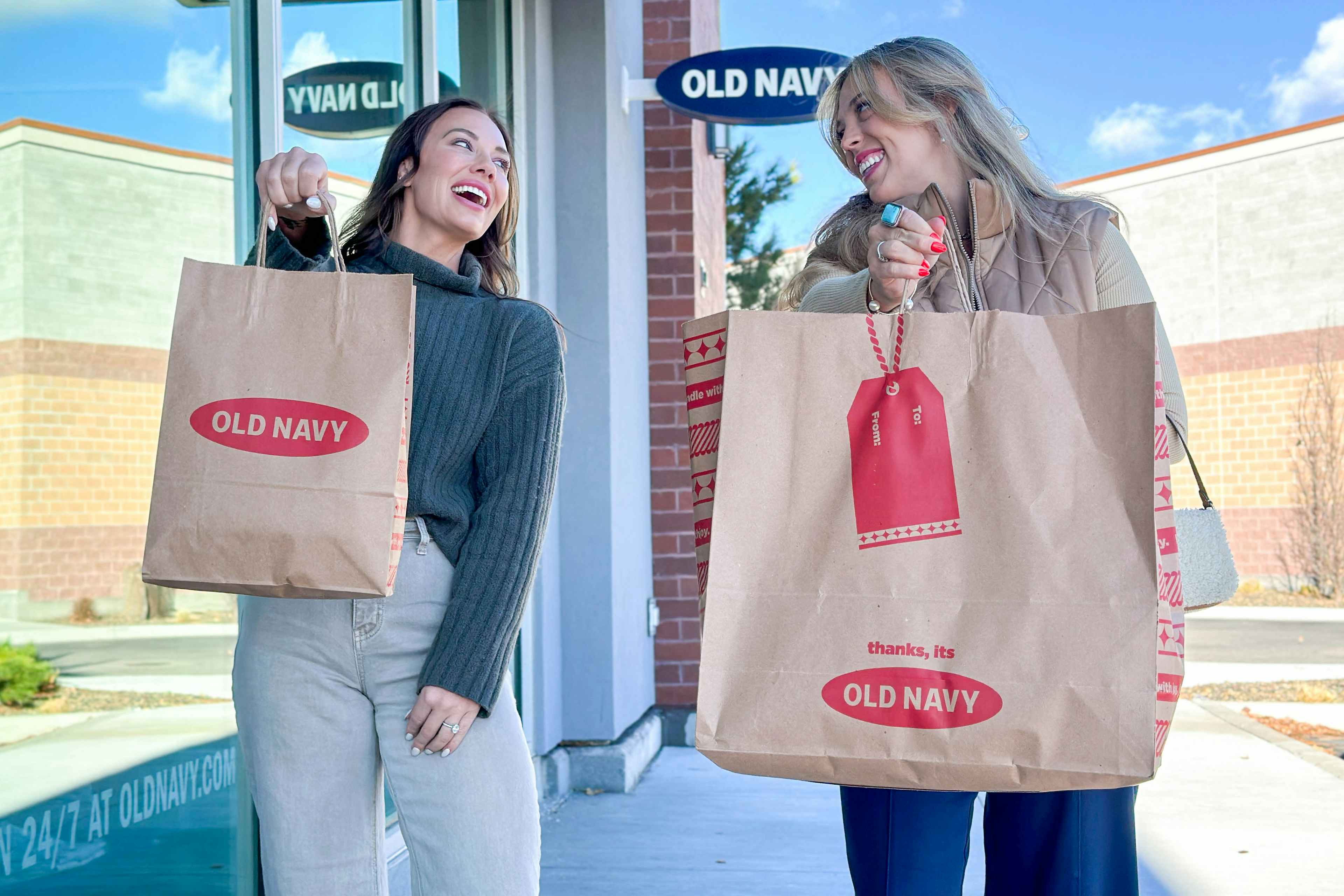 two women holding old navy bags 