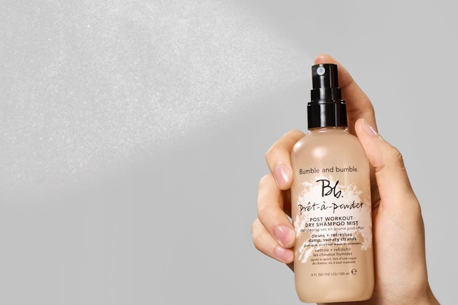 a woman spraying dry shampoo
