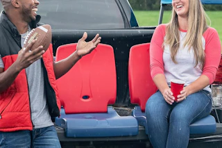 a woman and man sitting on folding chairs