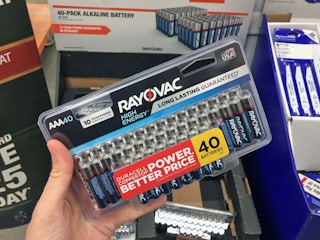 A person's hand holding a pack of 40 triple-A Rayovac batteries inside Home Depot.