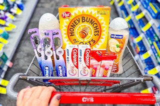 hand pushing cvs shopping cart filled with products