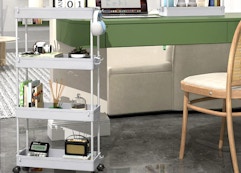 a rolling storage cart next to a chair and desk