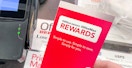 Someone holding an Office Depot rewards pamphlet at the checkout counter