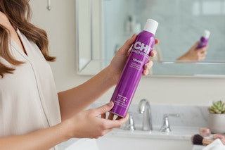 a woman holding chi hair spray